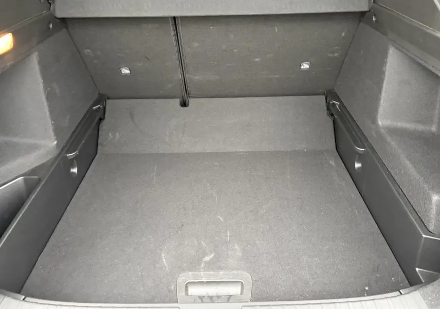 Coffre vide vu de face, plancher plat et revêtement noir, intérieur spacieux du Renault Arkana Bleu Zanzibar 2025.