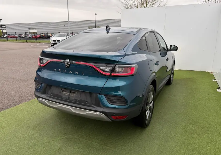 Vue 3/4 arrière droite d'une Renault Arkana bleu Zanzibar avec feux arrière LED et vitres surteintées.