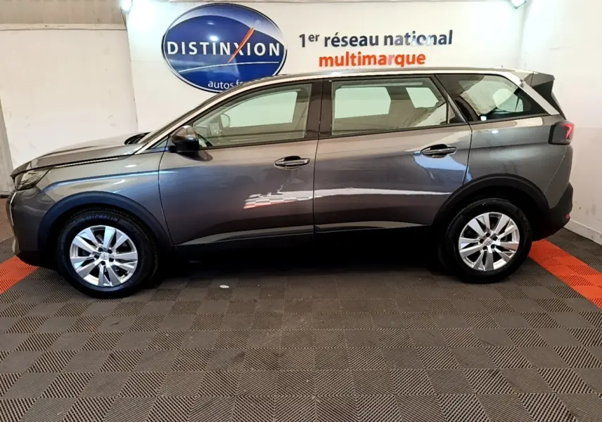 Profil côté gauche d’un Peugeot 5008 gris clair de 2021, avec jantes alliage et rétroviseurs électriques rabattables.