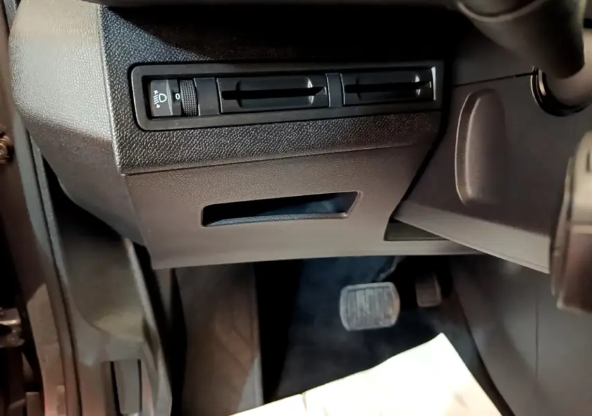 Détail de la console inférieure côté conducteur du Peugeot 5008 2021 avec commandes d’éclairage et pédalier visible.