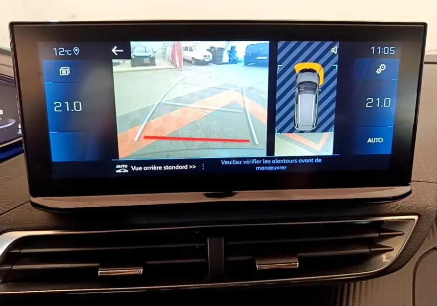 Écran tactile intérieur du Peugeot 5008 gris clair montrant la caméra de recul et l'aide au stationnement arrière.