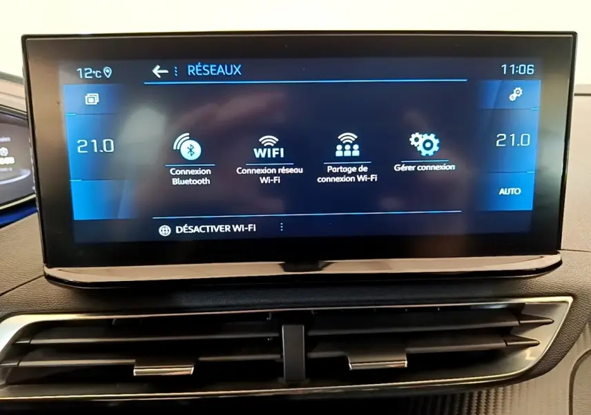 Écran tactile central affichant les options Wi-Fi et Bluetooth dans l'habitacle du Peugeot 5008 gris clair.