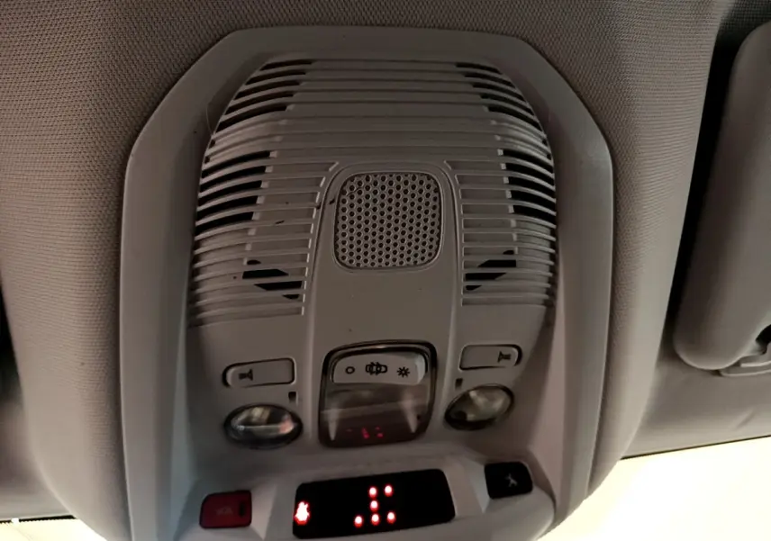 Vue intérieure en gros plan du plafonnier gris clair avec commandes d’éclairage et bouton SOS du Peugeot 5008 2021.