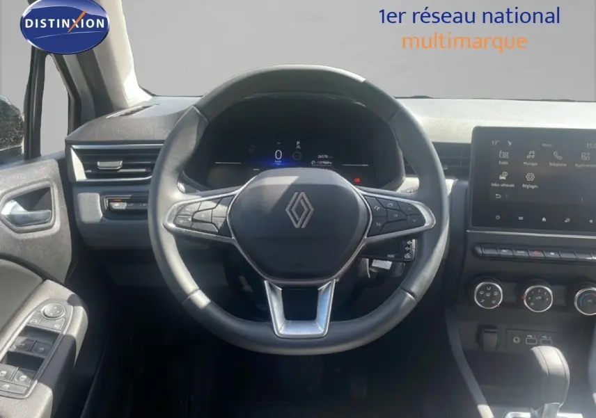 Vue centrée sur le volant et le tableau de bord noir d'une Renault Clio 2025 avec écran tactile et commandes intégrées.