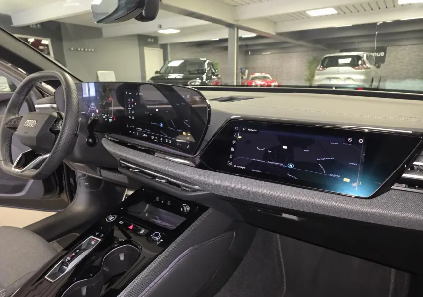 Vue intérieure côté conducteur de l'Audi A5 Avant 2025 noire, avec tableau de bord digital et écran tactile central.