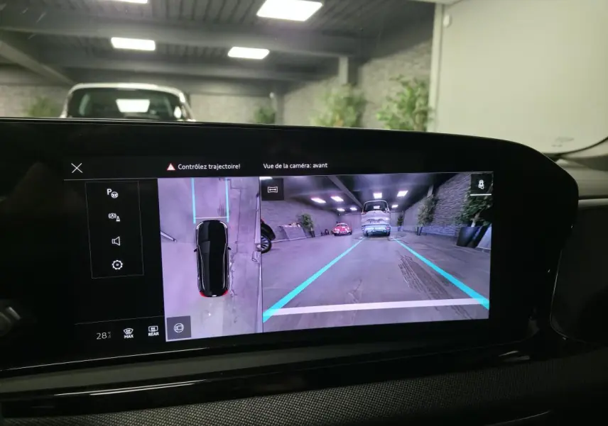 Écran intérieur affichant la caméra avant et vue 360° d'une Audi A5 Avant noire en parking couvert.