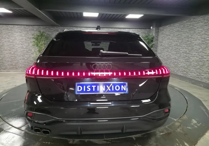 Vue arrière d'une Audi A5 Avant S line noire avec feux arrière LED continus et double sortie d'échappement chromée.