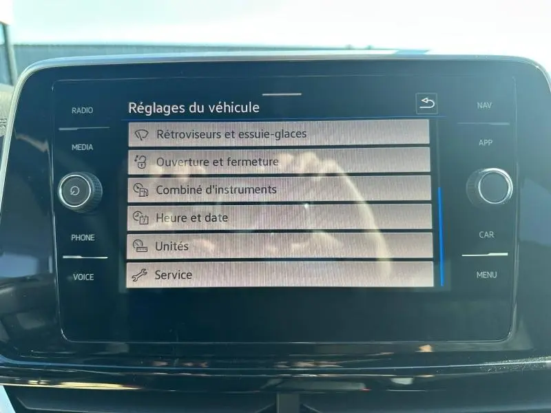 Écran tactile central du Volkswagen T-Roc 2025 affichant les réglages du véhicule, intérieur noir brillant.