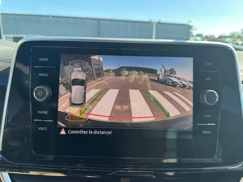 Écran tactile intérieur montrant la caméra de recul du Volkswagen T-Roc noir intense nacrée en marche arrière.