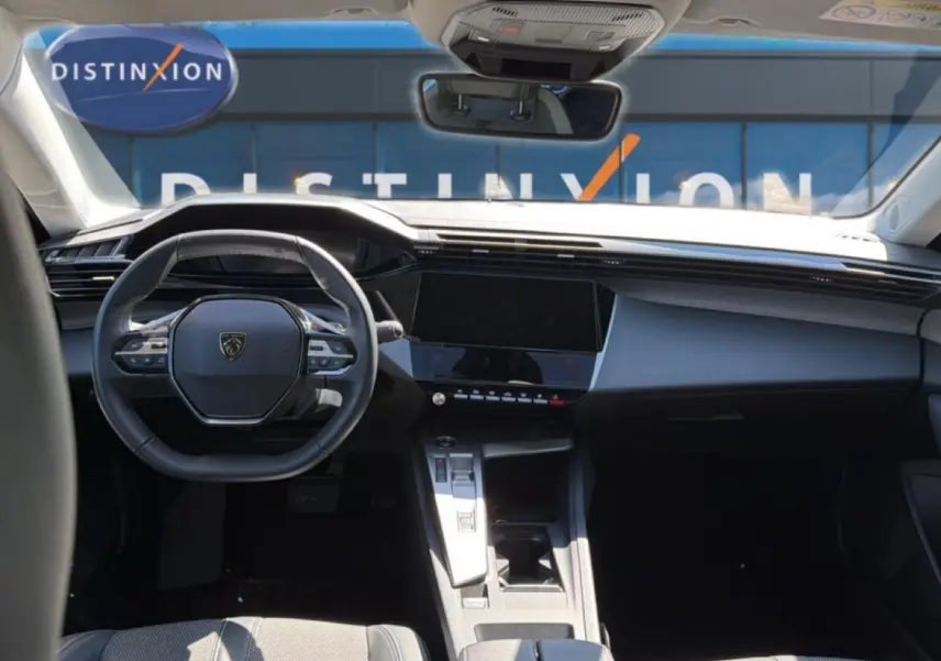 Intérieur avant de la Peugeot 408 Hybrid 145 bleu, vue centrée sur le volant et l'écran tactile du tableau de bord.