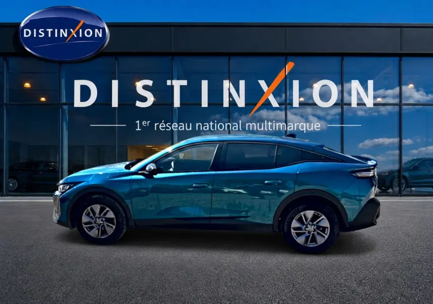 Profil gauche d'une Peugeot 408 Hybrid 145 allure bleu métallisé, avec jantes alu et vitres surteintées, devant une vitrine Distinxion.