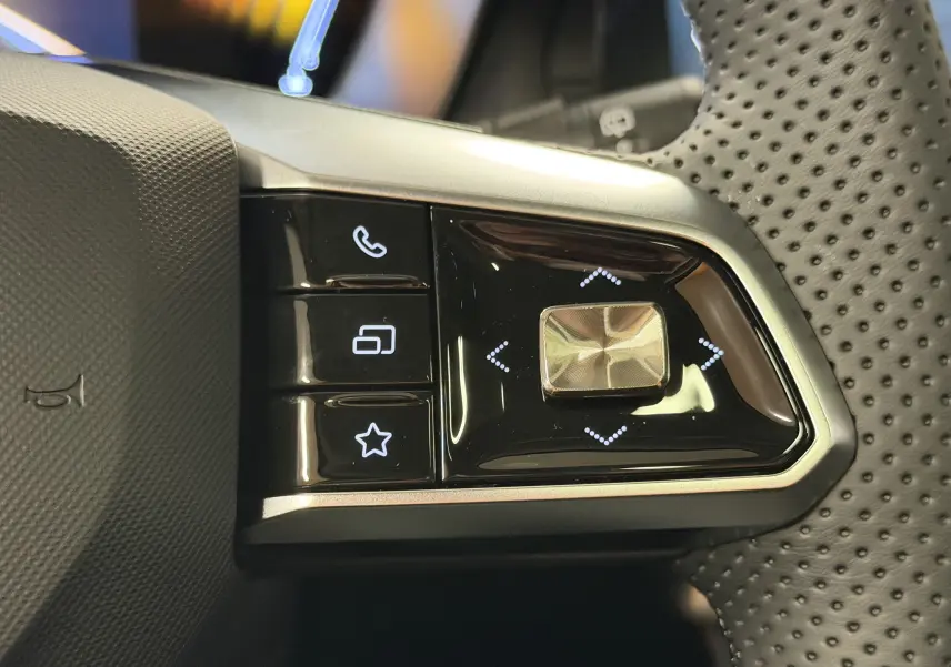 Gros plan sur les commandes multifonctions à droite du volant perforé du MG ZS noir 2026, avec boutons tactiles et joystick.