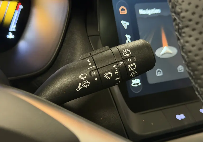 Gros plan sur la commande d’essuie-glace du MG Motor ZS 2026, avec écran tactile de navigation en arrière-plan.