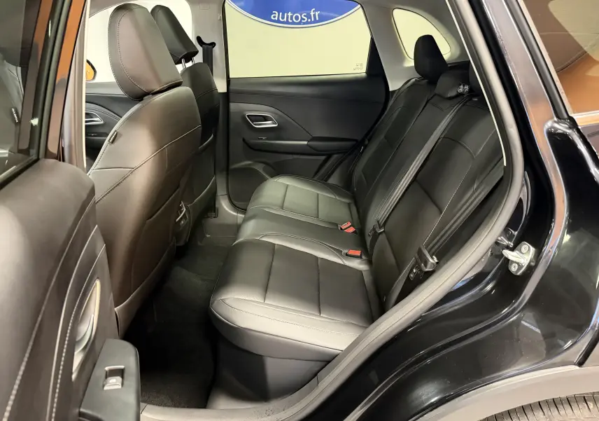 Intérieur arrière du MG ZS 2026 noir, vue côté gauche, sièges en similicuir noir perforé et ceintures visibles.