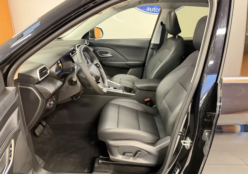 Vue intérieure côté conducteur du MG ZS 2026 noir, sièges en similicuir noir perforé avec réglage électrique et volant cuir.