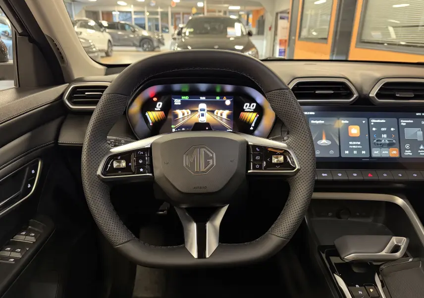 Vue intérieure centrée sur le volant en cuir perforé du MG ZS 2026 avec écran numérique et console tactile.