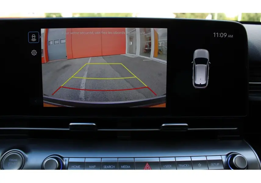 Écran tactile intérieur montrant la caméra de recul avec lignes de guidage actives sur Hyundai Kona 2024 rouge et toit noir.