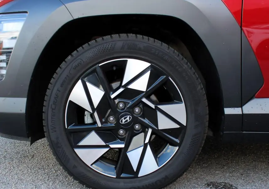 Gros plan sur la roue avant gauche du Hyundai Kona rouge Ultimate Metal avec jante alliage 17'' bicolore.