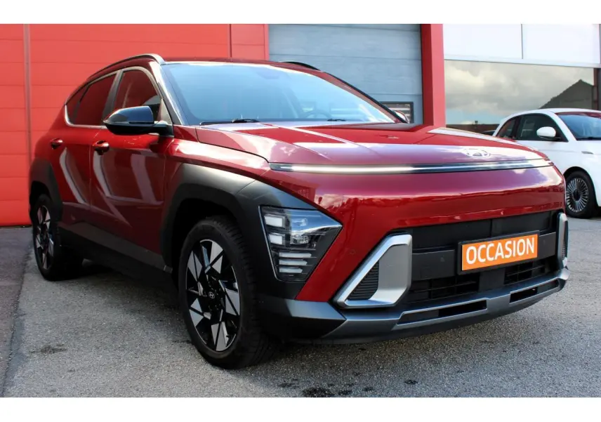 Hyundai Kona 2024 rouge Ultimate Metal avec toit noir, vue 3/4 avant mettant en valeur les feux LED et jantes alliage.