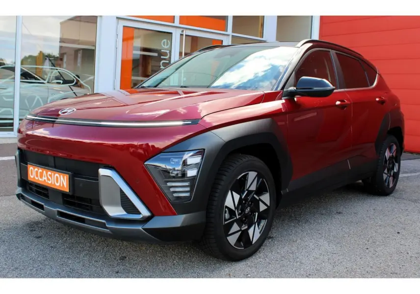 Vue 3/4 avant gauche d'un Hyundai Kona 2024 rouge Ultimate Metal avec toit noir et jantes alliage noires.