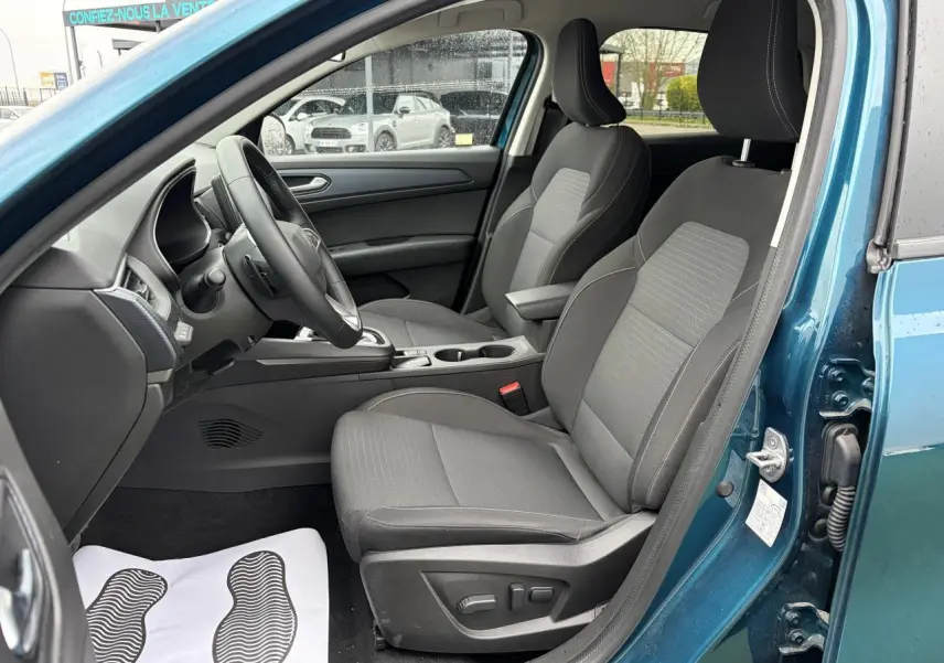 Vue intérieure côté conducteur de la Renault Arkana bleu Zanzibar, sièges gris avec réglages électriques visibles.