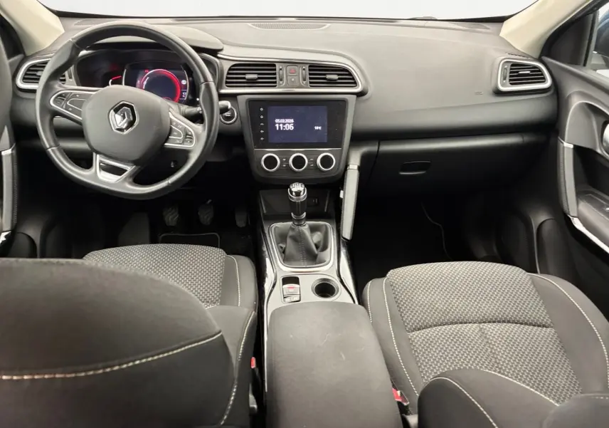 Vue intérieure avant du Renault Kadjar 1.5 Blue dCi 115 Business, tableau de bord noir avec volant multifonction et boîte manuelle.