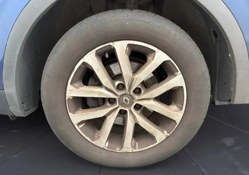 Gros plan sur la roue avant gauche du Renault Kadjar bleu cosmos, mettant en valeur la jante alliage 17 pouces et le logo central.