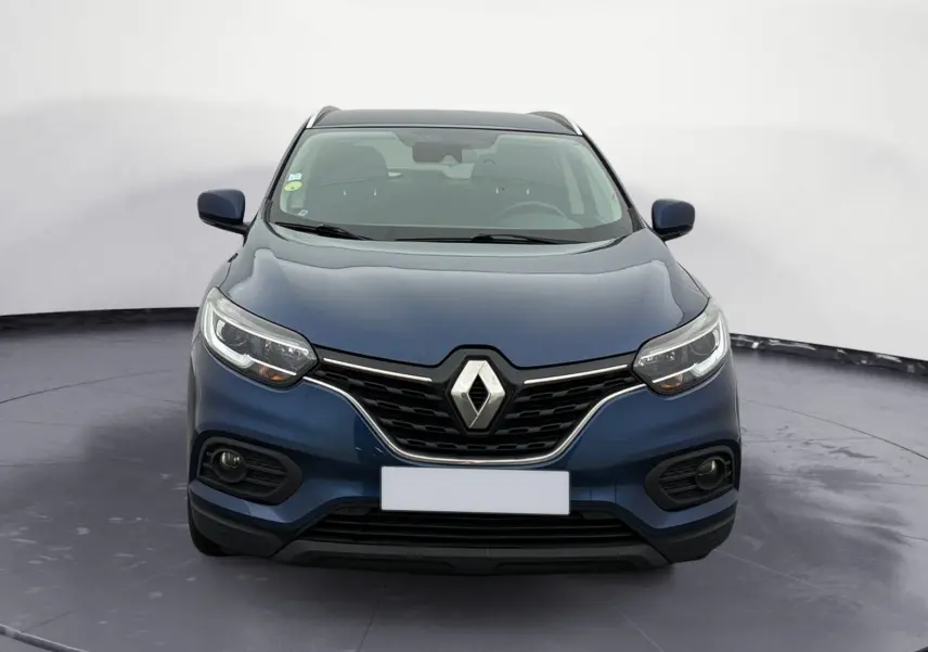 Vue frontale d'un Renault Kadjar 1.5 Blue dCi 115 Business bleu cosmos, avec calandre noire et phares LED allumés.