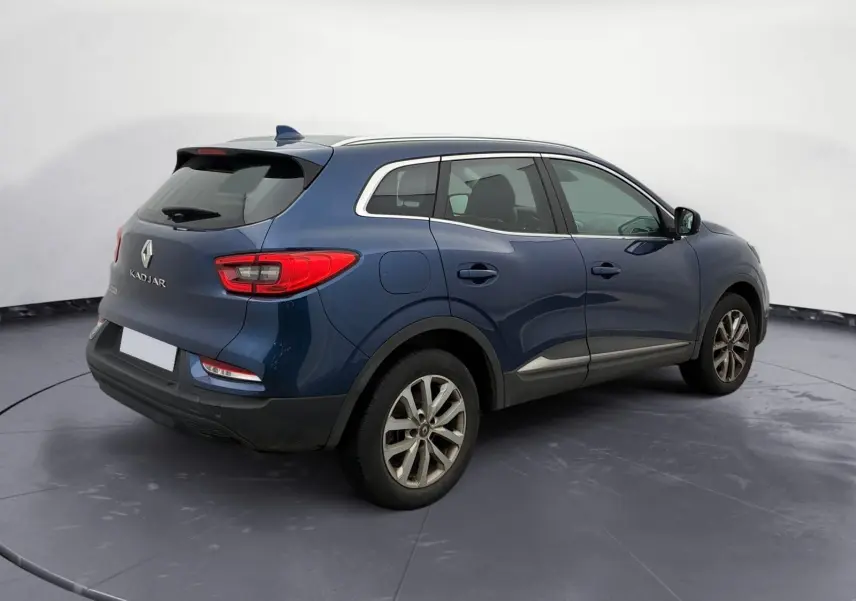 Vue 3/4 arrière droite du Renault Kadjar bleu cosmos 2020 avec jantes alliage et feux arrière allumés.