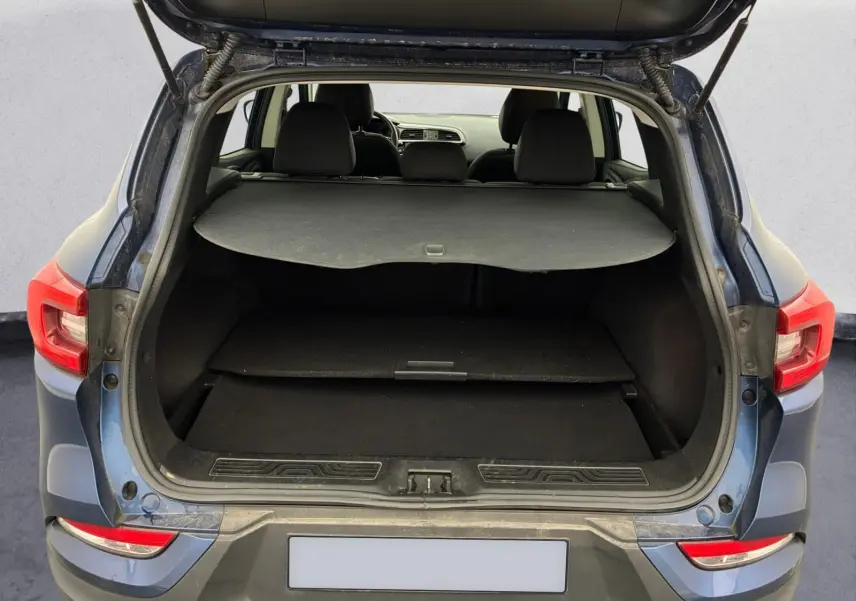 Vue arrière du coffre ouvert du Renault Kadjar bleu cosmos 2020, montrant l'espace de chargement et la tablette cache-bagages.