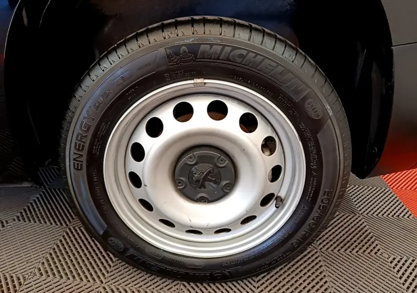 Gros plan sur la roue avant droite du Peugeot Partner noir, jante acier avec pneu Michelin Energy Saver.