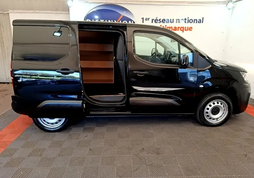 Vue latérale droite d’un Peugeot Partner noir 2022 avec porte coulissante ouverte montrant l’intérieur de chargement.