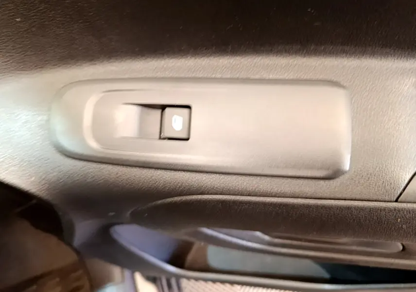 Détail du bouton de verrouillage des portes sur la portière intérieure côté conducteur du Peugeot Partner noir 2022.
