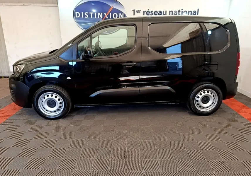 Vue latérale droite d’un Peugeot Partner noir 2022 avec jantes acier et vitres arrière teintées.