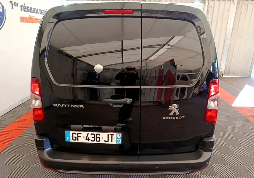 Vue arrière d’un Peugeot Partner noir 2022 avec portes battantes et plaque d’immatriculation française visible.