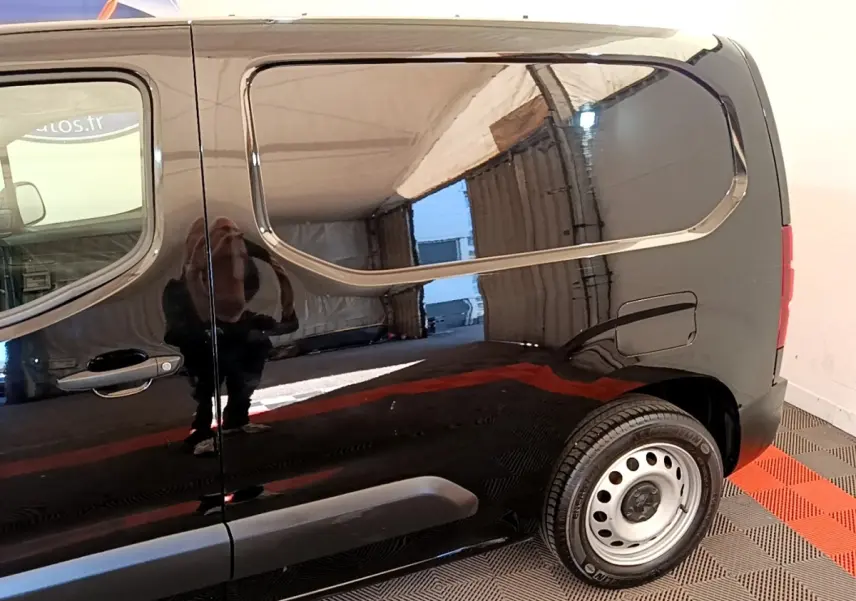 Vue latérale droite du Peugeot Partner noir 2022 avec jante acier et porte latérale coulissante fermée.