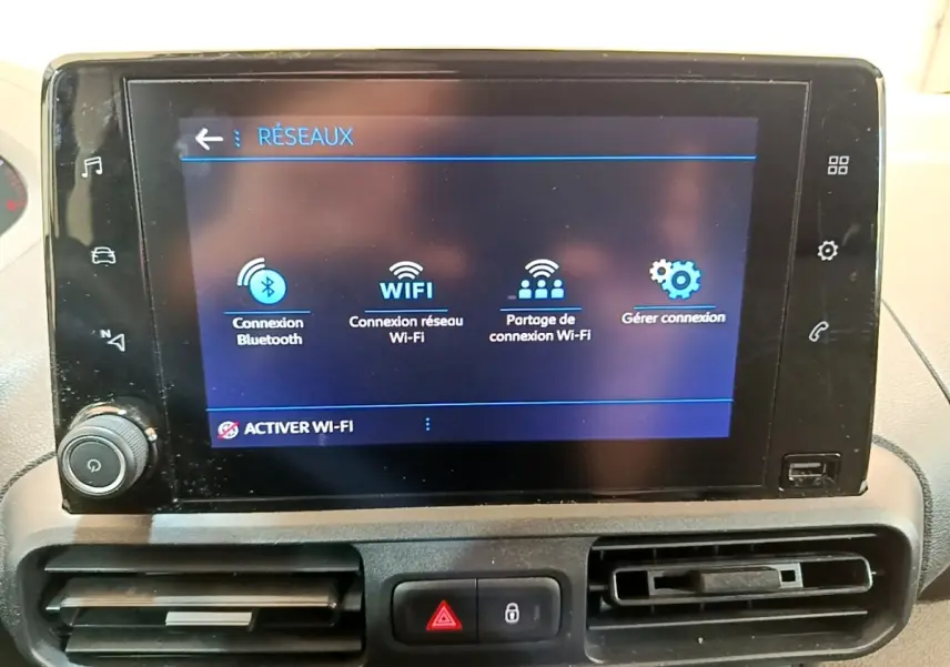 Écran tactile central affichant les options réseau Wi-Fi et Bluetooth dans l'habitacle du Peugeot Partner noir.