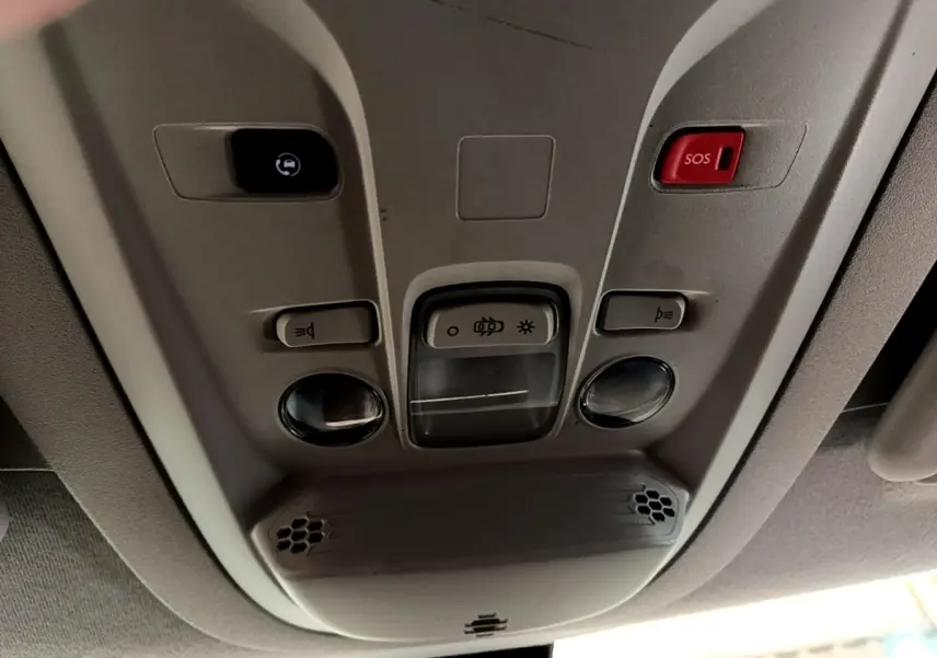 Vue en gros plan du plafonnier intérieur du Peugeot Partner noir, avec boutons d’éclairage et alerte SOS rouge.