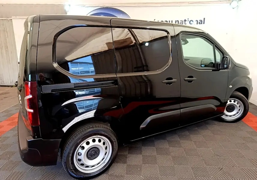 Vue de profil droit d’un Peugeot Partner noir 2022, fourgon utilitaire avec jantes acier et vitres teintées.
