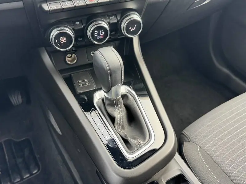 Vue rapprochée de la console centrale du Renault Arkana 2025 avec levier de boîte automatique et commandes de climatisation.