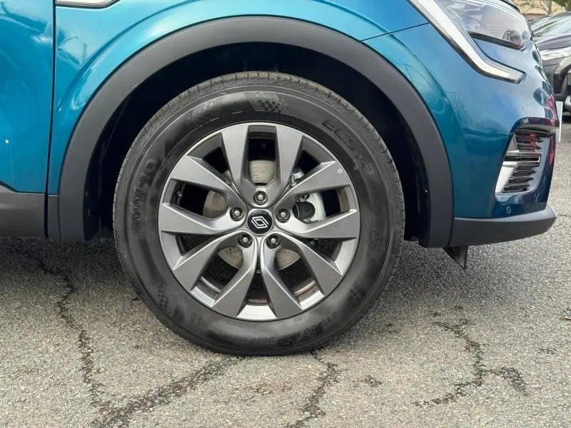 Gros plan sur la roue avant gauche du Renault Arkana 2025 bleu Zanzibar avec jante alliage et partie avant du véhicule visible.