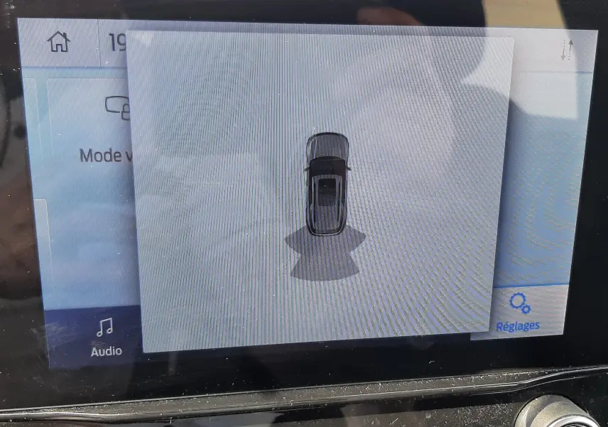 Écran central montrant la vue aérienne du Ford Puma blanc 2022 avec capteurs de proximité activés.