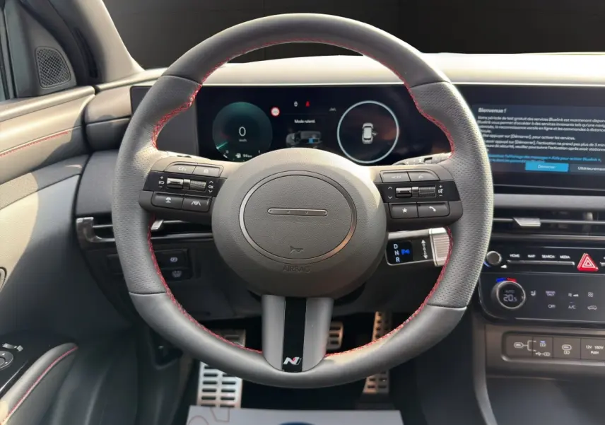 Vue intérieure centrée sur le volant sport cuir noir avec surpiqûres rouges du Hyundai Tucson 1.6 Hybrid N Line 2026.