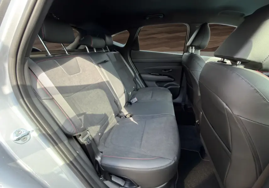 Vue intérieure côté gauche des sièges arrière en cuir noir et tissu gris du Hyundai Tucson 1.6 Hybrid gris clair 2026.