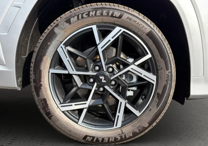 Gros plan sur la roue avant droite gris clair du Hyundai Tucson 1.6 Hybrid N Line avec jante alliage noire et détails argentés.