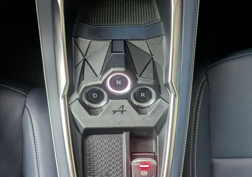 Vue plongeante sur la console centrale noire de l'Alpine A290 220CH GTS avec commandes de boîte auto et cuir bleu.
