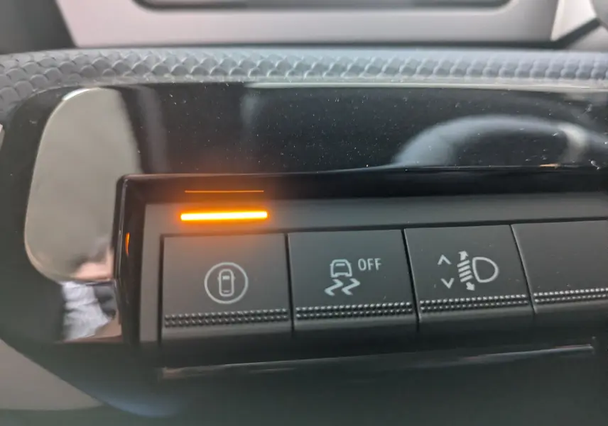 Gros plan sur les boutons de commande intérieurs de l'Alpine A290 220CH GTS, avec témoin orange allumé.