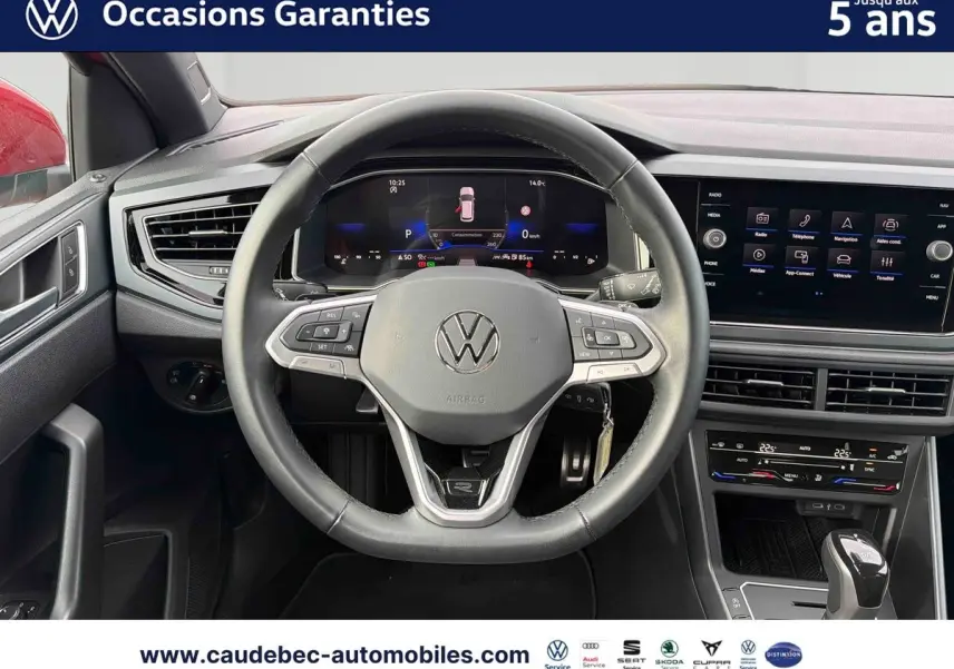 Vue intérieure centrée sur le volant cuir multifonctions et le tableau de bord digital de la Volkswagen Polo rouge 2025.