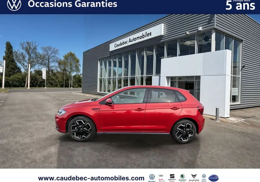 Profil droit d'une Volkswagen Polo rouge 2025 avec jantes alliage 17 pouces, stationnée devant un bâtiment moderne.