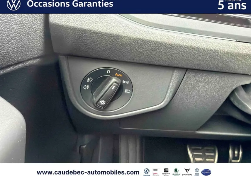 Gros plan sur le sélecteur d’éclairage intérieur de la Volkswagen Polo rouge, avec pédales en arrière-plan.